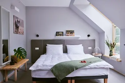 a bedroom with a large bed with white sheets at Barono Vila in Butėnai