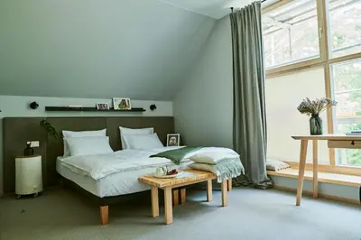 a bedroom with a bed and a table and a window at Barono Vila in Butėnai