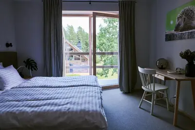 a bedroom with a bed and a desk and a window at Barono Vila in Butėnai