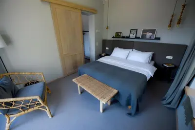 a small bedroom with a bed and a chair at Barono Vila in Butėnai