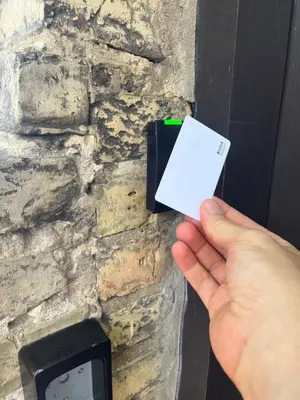 a person holding a card in front of a stone wall at Green apple - Self check-in - Free parking in Vilnius