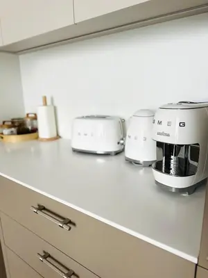 a kitchen counter with three toasters and a microwave at Cozy Riverside Apartment in Birštonas