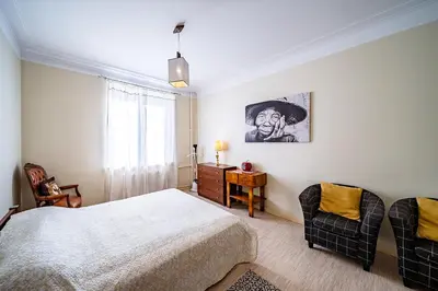 a bedroom with a bed and two chairs at Guido apartament in Šiauliai