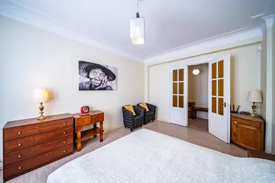 a bedroom with a bed and a dresser and a chair at Guido apartament in Šiauliai