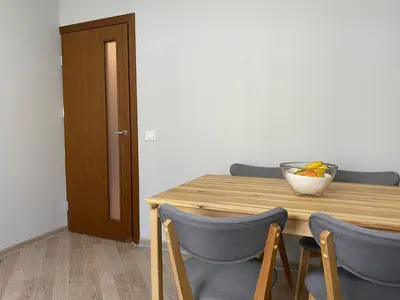 a wooden table with chairs and a bowl of fruit on it at Čiurlionio 5 in Druskininkai
