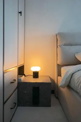 a small table with a lamp next to a bed at Vilnius Luxury Appartement in Vilnius
