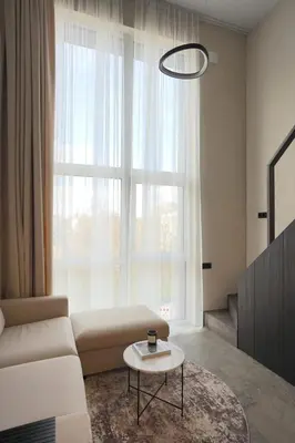 a living room with a couch and a table in front of a window at Vilnius Luxury Appartement in Vilnius