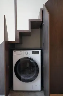 a washing machine in a cabinet with a staircase at Vilnius Luxury Appartement in Vilnius