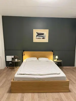 a bedroom with a large bed with a wooden headboard at Domillion 1bdr Quiet City Hall apt D1115 in Vilnius