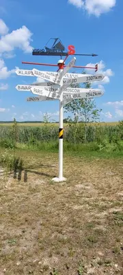 a street sign with many signs on it in a field at Vigio Brasta camping in Elektrėnai
