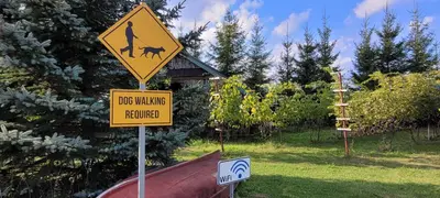 a dog walking sign in front of a car at Vigio Brasta camping in Elektrėnai