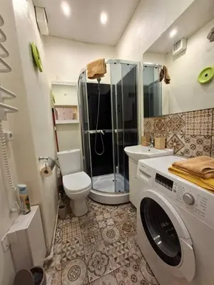 a bathroom with a shower and a washing machine at Aguona namai apartamentai in Kaunas
