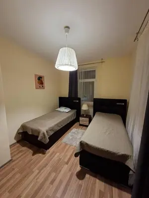 a bedroom with two beds and a chandelier at Aguona namai apartamentai in Kaunas