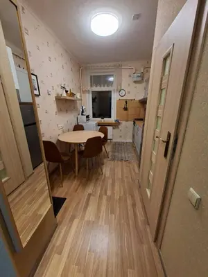 a kitchen and dining room with a table in a room at Aguona namai apartamentai in Kaunas