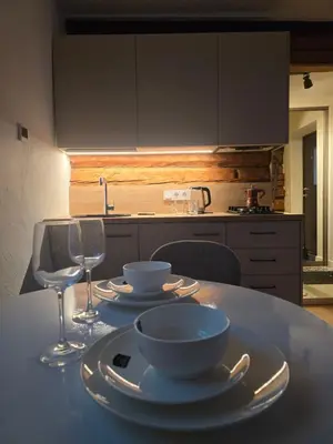 a kitchen with a table with plates and wine glasses at TRoBA in Vilnius