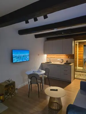 a kitchen and a living room with a table and chairs at TRoBA in Vilnius