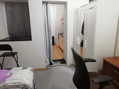 a bedroom with a door open to a room with a bed and chairs at Frankes Cozy One Bedroom Apartment in Vilnius