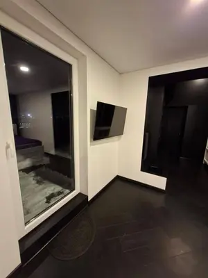a room with a large window and a tv at Kauno buzo namuciai in Kaunas