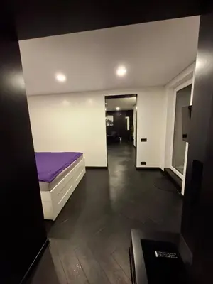 a bedroom with a purple bed and a hallway at Kauno buzo namuciai in Kaunas