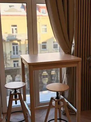 a table and two stools in front of a window at Central Svitrigaila Apartments in Vilnius