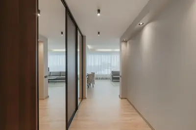 a hallway with a mirror and a living room at Skyline View Apartment Vilnius in Vilnius