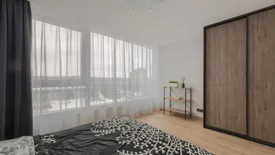 a bedroom with a bed and a large window at Skyline View Apartment Vilnius in Vilnius