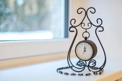 a clock sitting on a shelf in a window at Antique apartment by Polo Apartments in Kaunas