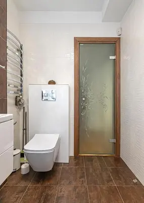 a bathroom with a toilet and a glass door at Antique apartment by Polo Apartments in Kaunas