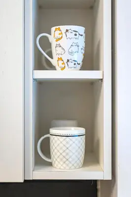 a cup and a mug in a cabinet at Antique apartment by Polo Apartments in Kaunas