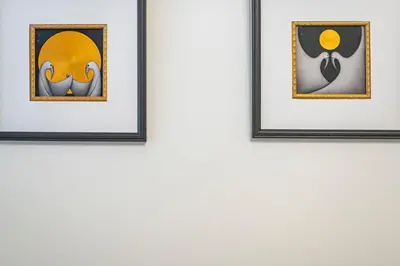two framed pictures hanging on a white wall at Antique apartment by Polo Apartments in Kaunas