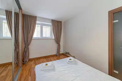 a bedroom with a bed and two windows at Antique apartment by Polo Apartments in Kaunas