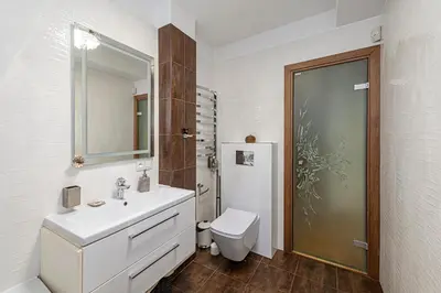 a white bathroom with a sink and a toilet at Antique apartment by Polo Apartments in Kaunas