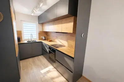a kitchen with stainless steel appliances and wooden cabinets at Klevų 41 Townhouse, Noreikiskes in Kaunas