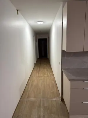 an empty hallway with white walls and a wooden floor at SALGIRDO svečių namai in Kelmė