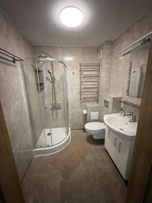 a bathroom with a shower and a toilet and a sink at SALGIRDO svečių namai in Kelmė