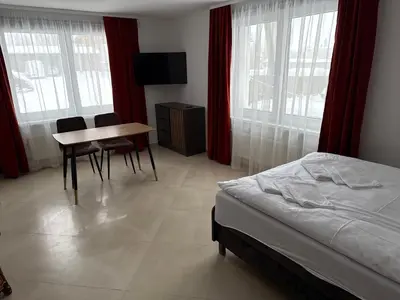 a bedroom with a bed and a table and chairs at SALGIRDO svečių namai in Kelmė