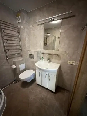 a bathroom with a sink and a toilet and a mirror at SALGIRDO svečių namai in Kelmė
