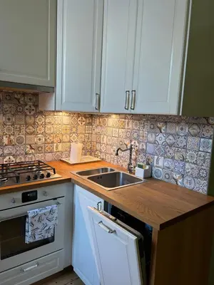 a kitchen with white cabinets and a sink at City Park Apartment in Vilnius