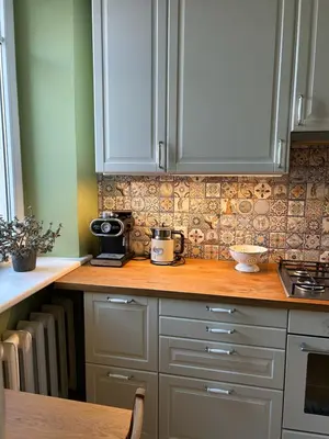 a kitchen with white cabinets and a wooden counter top at City Park Apartment in Vilnius