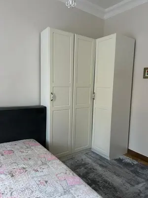 a bedroom with white cabinets and a bed at City Park Apartment in Vilnius