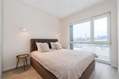 a bedroom with a bed and a large window at Modern Apartment next to Kaunas Clinics in Kaunas