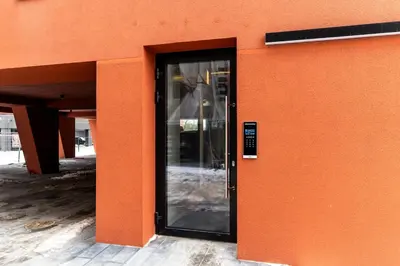 an orange building with a glass door on it at Modern Apartment next to Kaunas Clinics in Kaunas