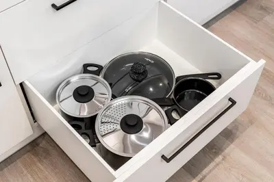 a white drawer filled with pots and pans at Modern Apartment next to Kaunas Clinics in Kaunas