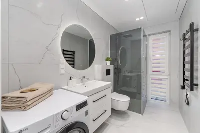 a white bathroom with a sink and a mirror at Modern Apartment next to Kaunas Clinics in Kaunas