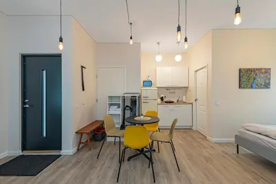 a living room with a table and chairs and a kitchen at Studio apartment Delight by Polo Apartments in Kaunas