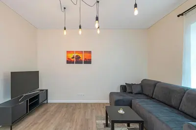 a living room with a couch and a tv at Studio apartment Delight by Polo Apartments in Kaunas