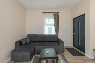 a living room with a black couch and a window at Studio apartment Delight by Polo Apartments in Kaunas