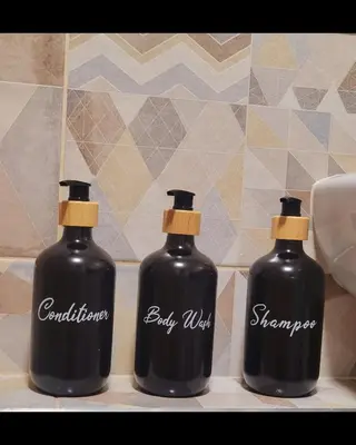 two bottles of soap sitting on a bathroom counter at Mocha House 2-Bedroom Apartment Netflix Speedy Wifi in Kaunas