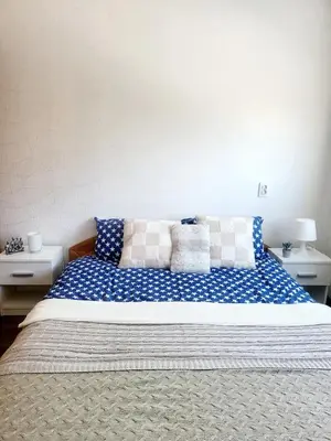 a bed with blue and white pillows on it at Mocha House 2-Bedroom Apartment Netflix Speedy Wifi in Kaunas