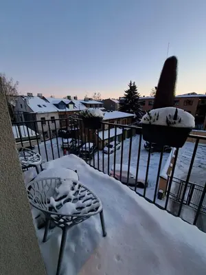 a balcony covered in snow with chairs and a fountain at Viktor Nemuno house in Kaunas